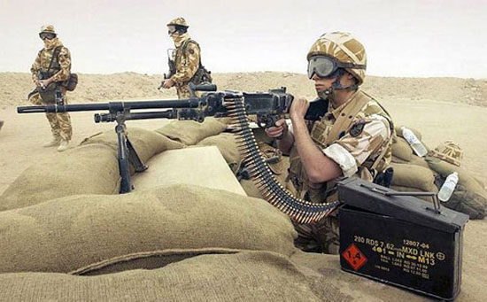 A member of 653 Squadron, 3 Army Air Corps, ground crew provides protection for the two soldiers on guard with his GPMG (General Purpose Machine Gun). 